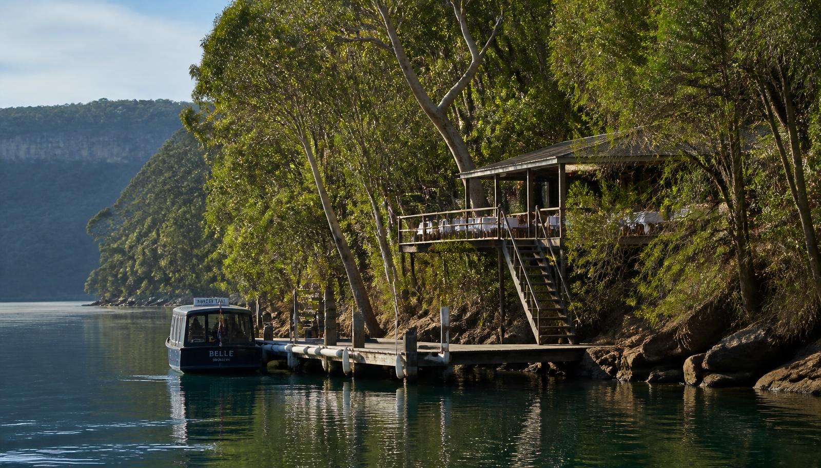 Water taxi at the jetty of a hidden Hawkesbury River restaurant surrounded by steep eucalyptus bushland