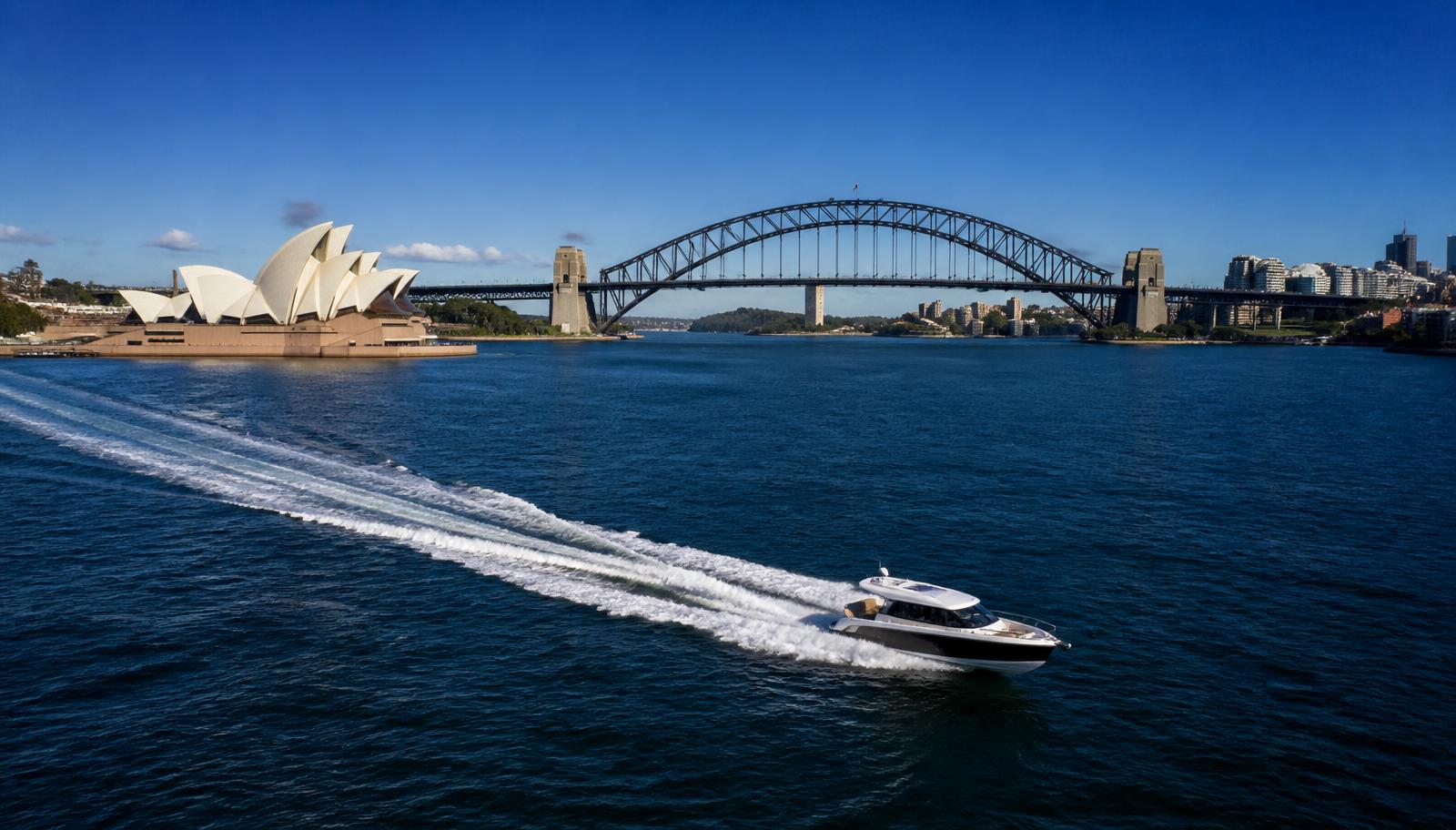 Private water taxi running fast across Sydney Harbour with the Harbour Bridge and Opera House in the background
